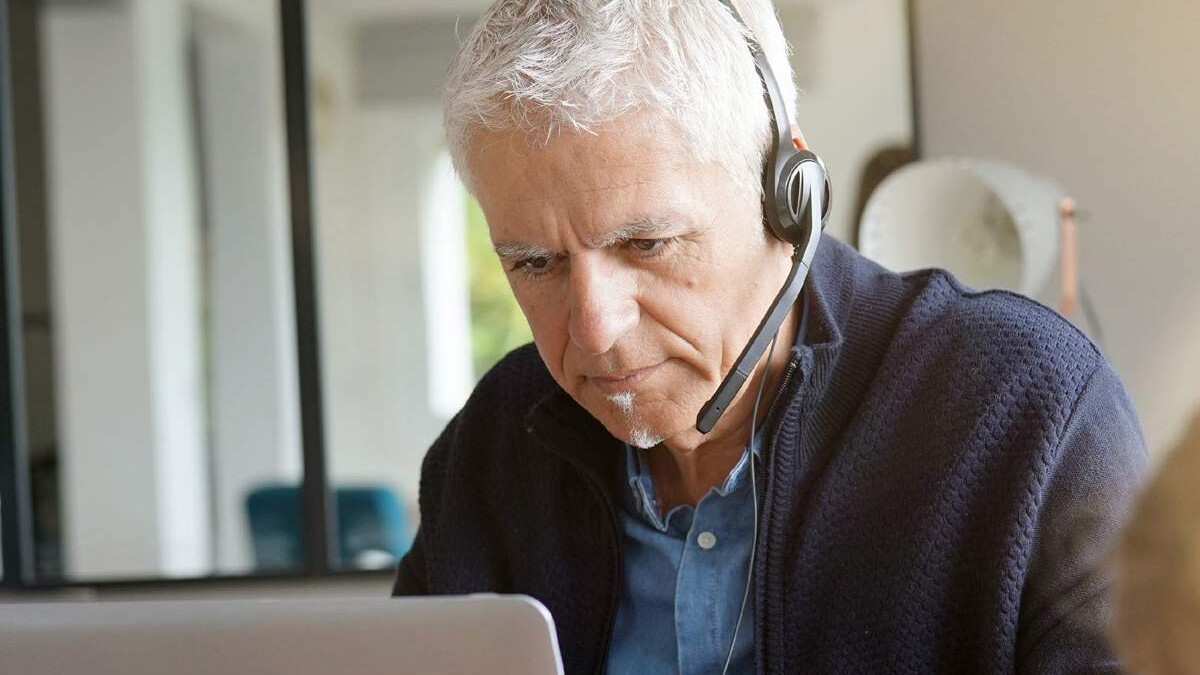 older man with headset on