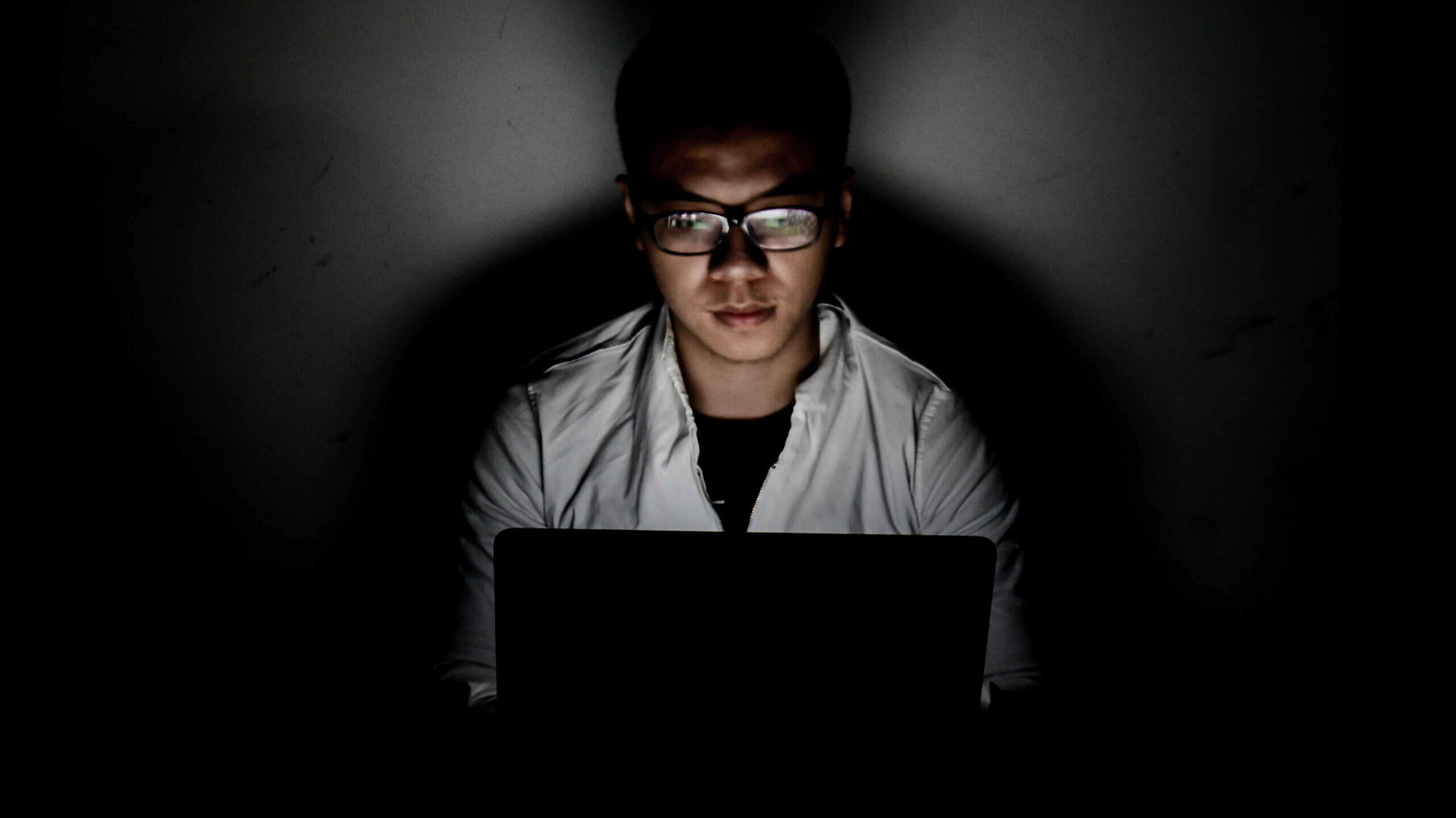 man in dark room on laptop