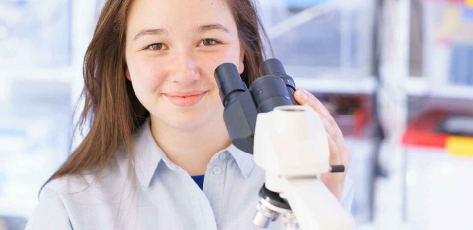 female student using microscope