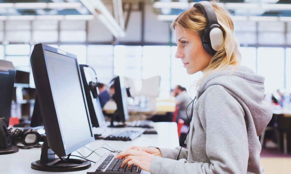 female worker with gray hoodie and headphones
