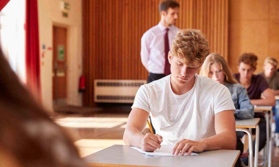student in white shirt taking paper exam