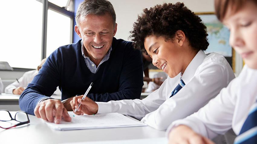 smiling teacher helping student