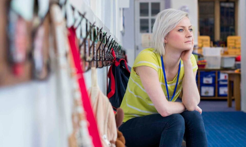 blonde gym teacher in yellow top looking into distance