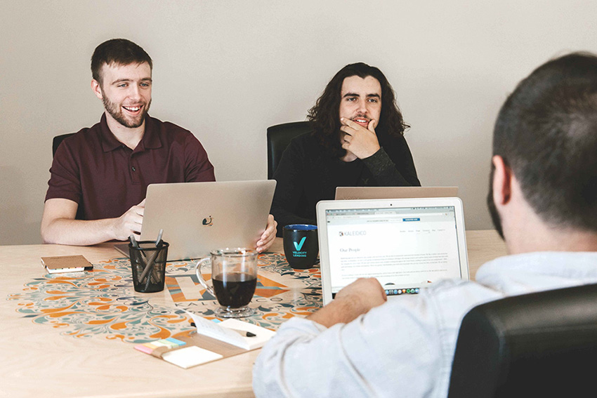 two young guys in a meeting with laptops