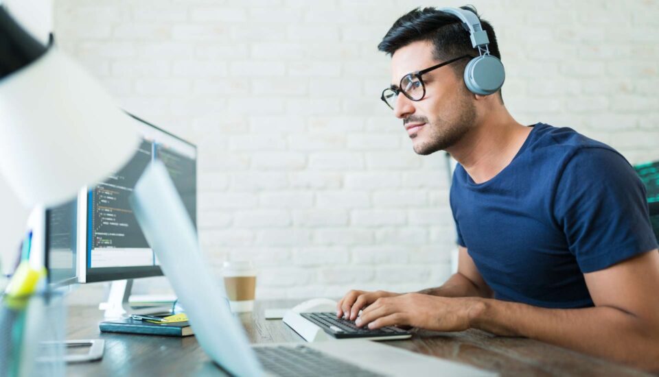 professional man wearing glasses and headphones at computer