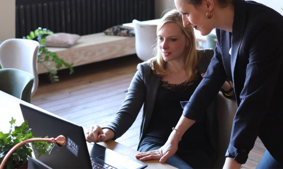 two female colleagues looking at laptop