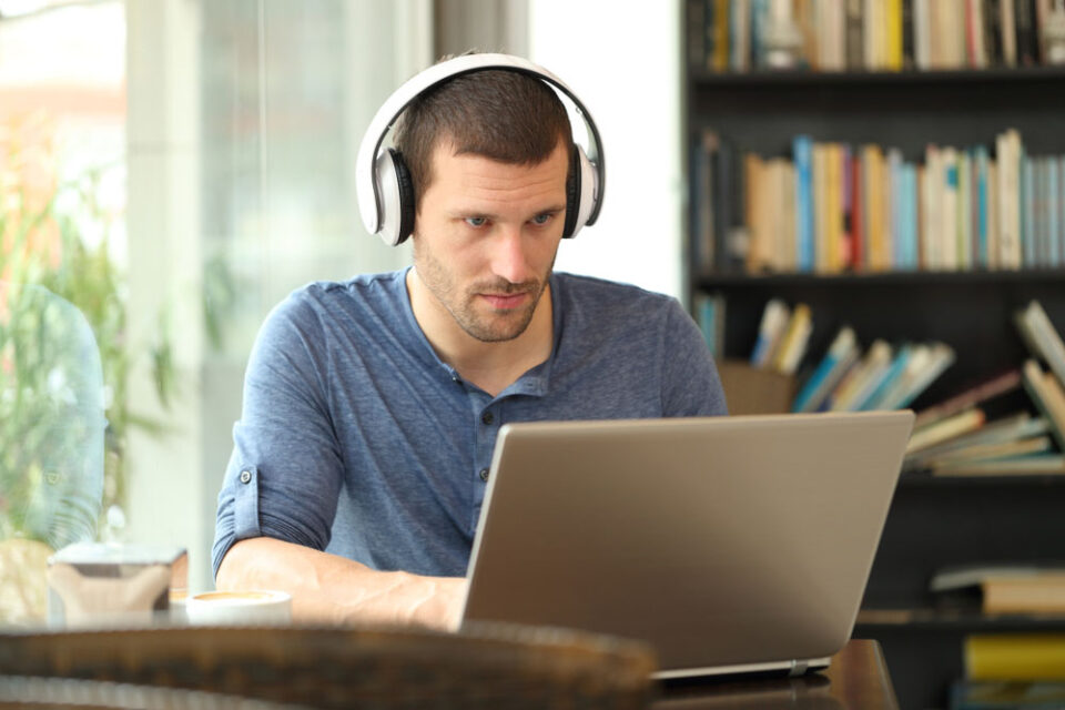 concerned man using headphones with laptop