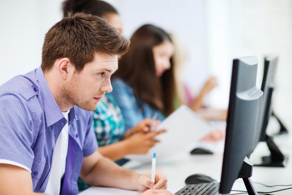 man in blue shirt on computer