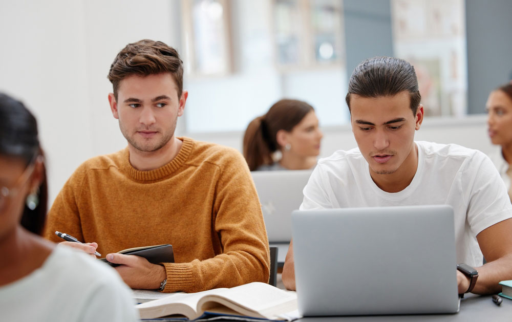 student looking at someone else's laptop