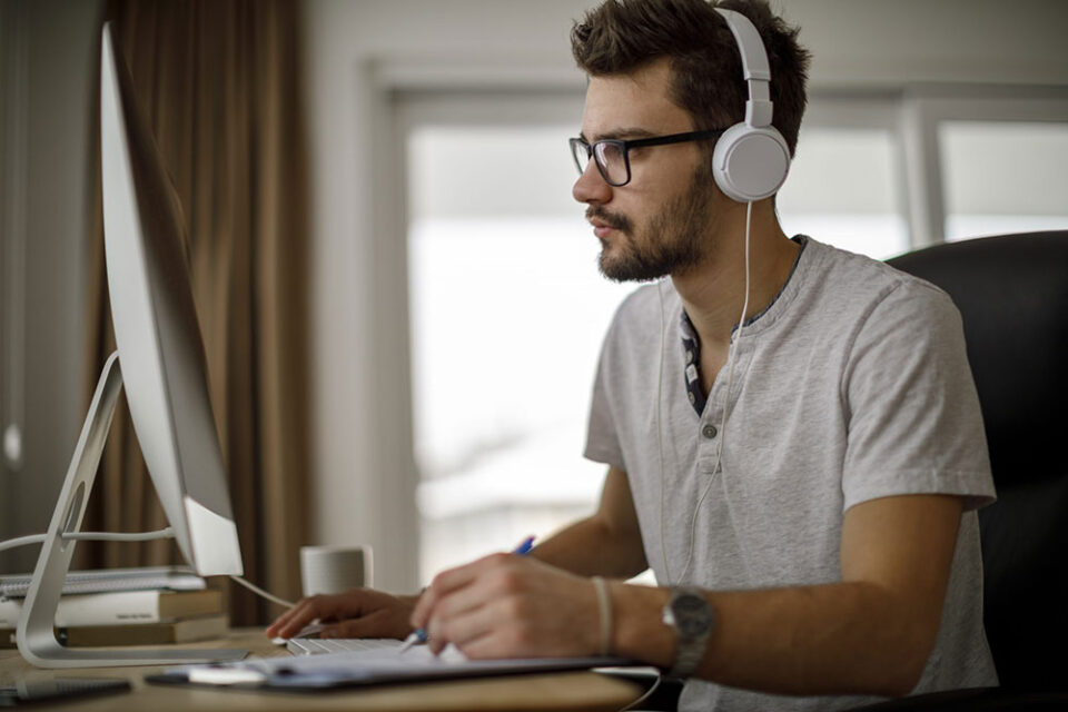 man wearing headphones working on computer