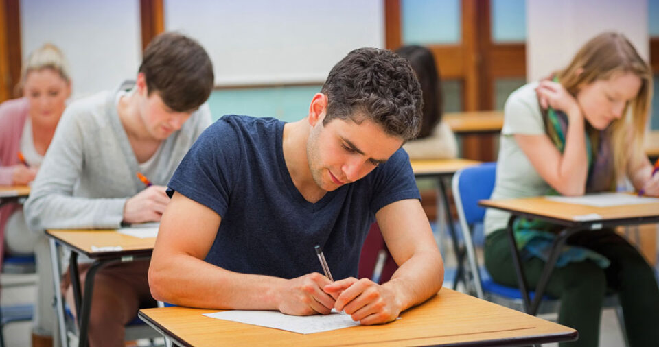 man at desk completing paper assessment