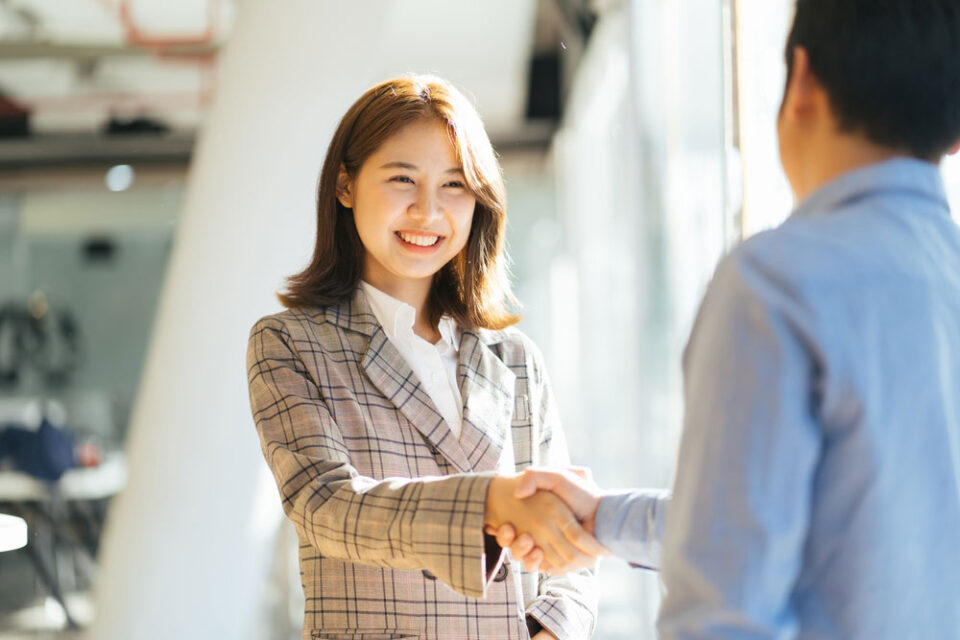 lady in chequered jacket shaking hands with man