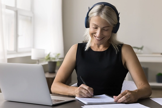 lady writing something down, working on examination testing software