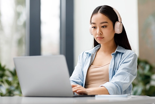 girl in headphones working on online testing software