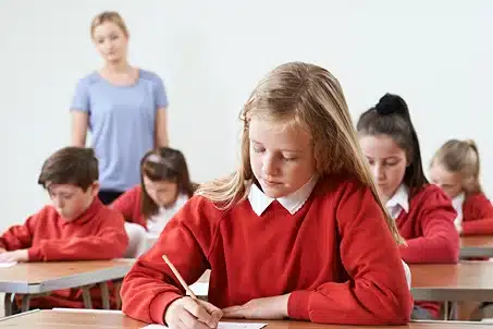 school kids in red uniforms at desks