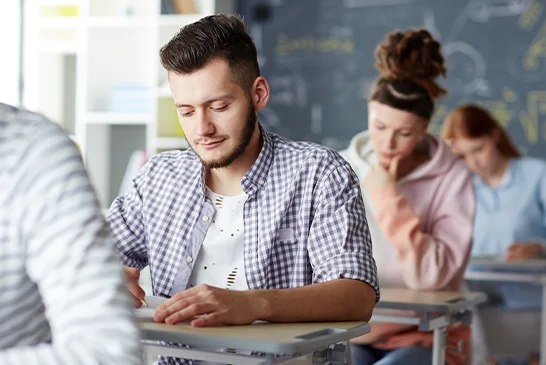 man in shirt taking paper exam