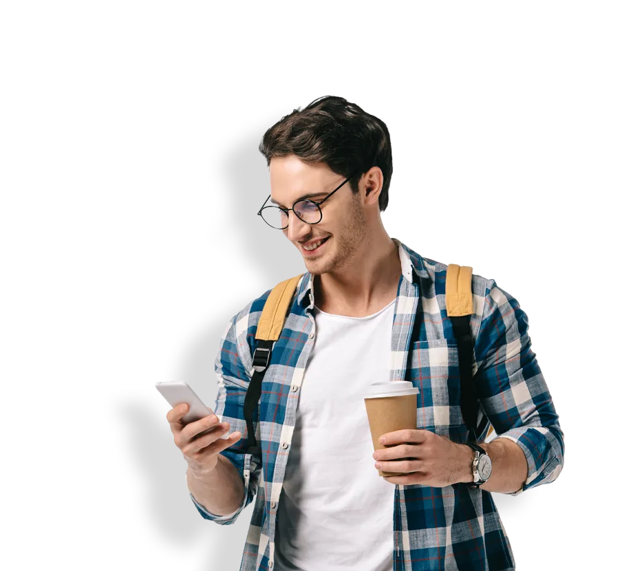 man in chequered shirt looking at phone holding coffee