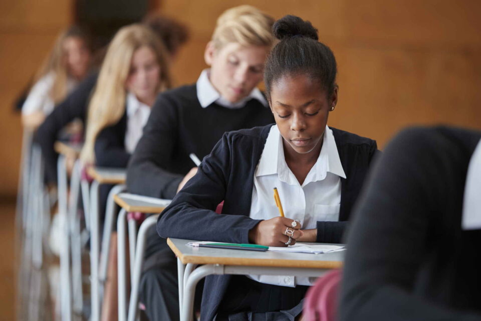 students in exam hall taking paper exams